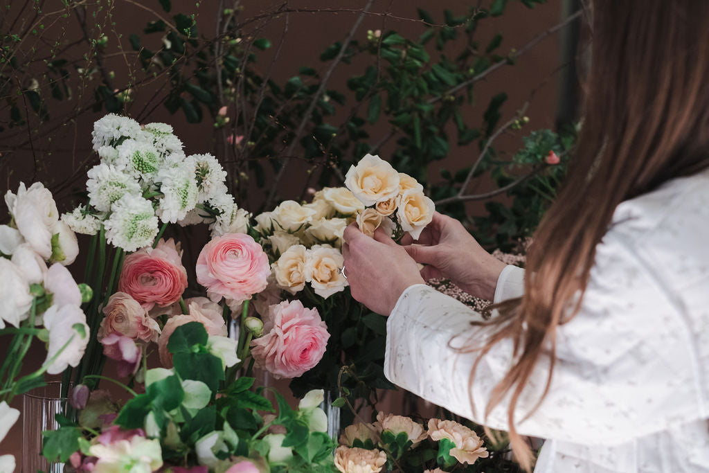 The Dreamt Garden Madison AL florist arranging flowers with a focus on hands and flowers.  Teaches flower workshops at flower shop in Madison AL.