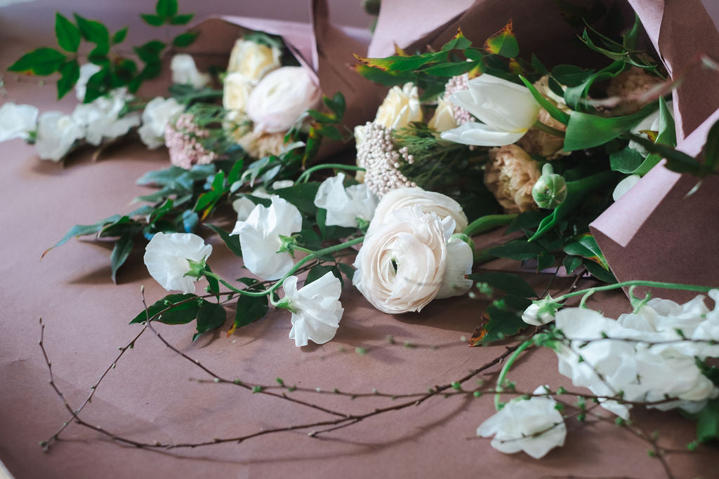 A close-up bouquet of white and blush pink flowers with green leaves.  The Dreamt Garden Madison AL hand-tied bouquet from the flower shop's Flower Bar for daily flower deliveries in Madison, Alabama.