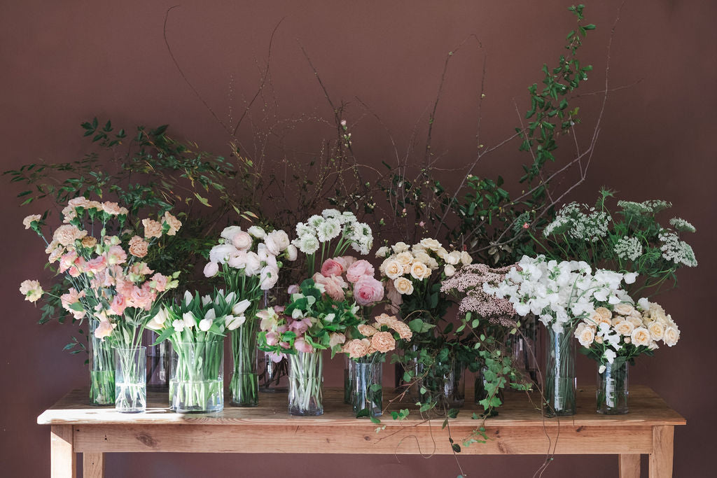Flower bar with roses, tulips, hellebores, carnations, ranunculus, queen anne's lace in shades of pink peach and white.  Flower shop in Madison Alabama.