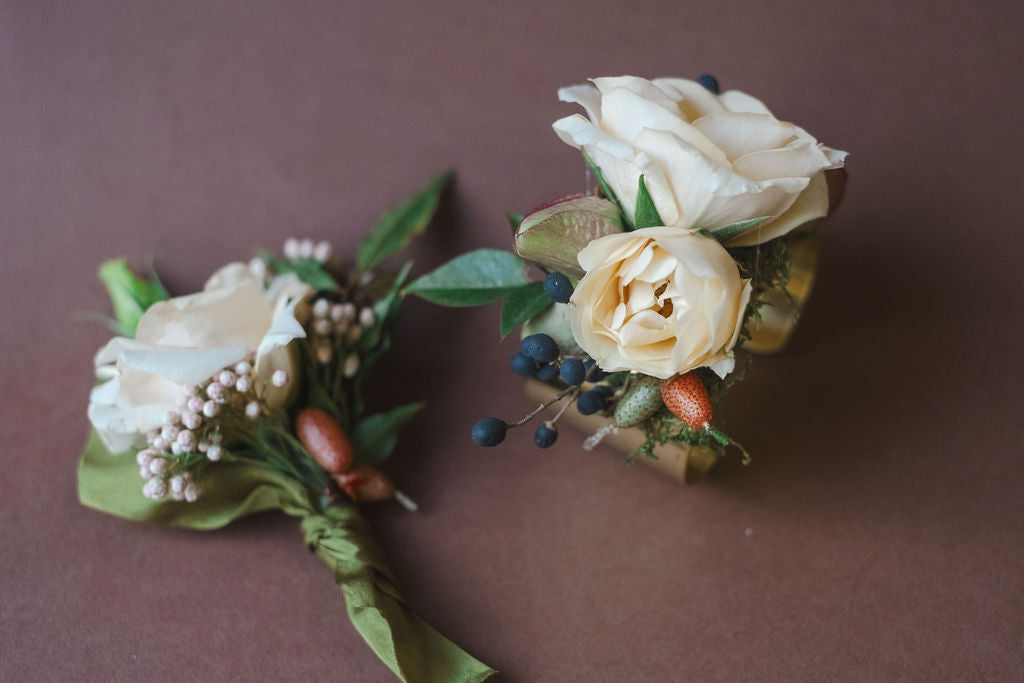 Two floral boutonnieres with beige roses and greenery, designed by The Dreamt Garden in Madison AL for Prom, Homecoming, Formals, and other Dance  flowers.