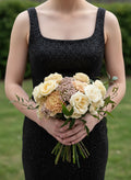 Female wearing a black dress holding a bouquet of flowers. Small posey bouquet purchased for Prom, Homecoming, Formals, and other Dances in Madison, Huntsville, and Athens, AL.
